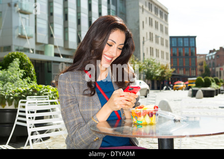 Gemischte Rassen Frau Essen in städtischen Straßencafé Stockfoto