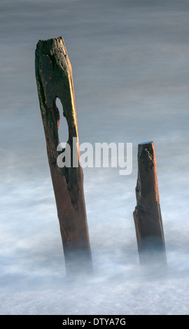 Das Meer wäscht auf den Resten eines längst vergangenen Steg entlang des Strandes von Winchelsea in East Sussex. UK Stockfoto