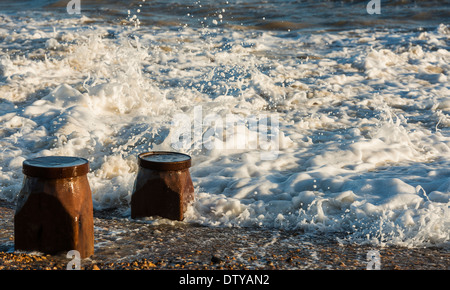 Das Meer wäscht auf den Resten eines längst vergangenen Steg entlang des Strandes von Winchelsea in East Sussex. UK Stockfoto