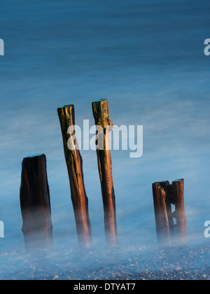 Das Meer wäscht auf den Resten eines längst vergangenen Steg entlang des Strandes von Winchelsea in East Sussex. UK Stockfoto