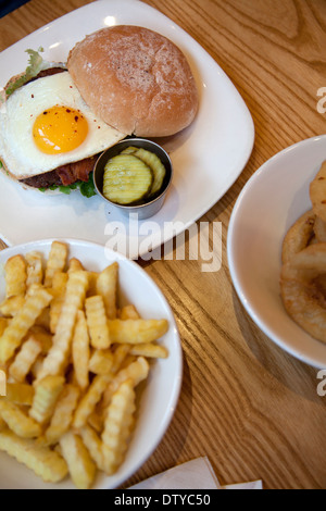 Burger mit gebratenem Ei und Pommes frites Stockfoto