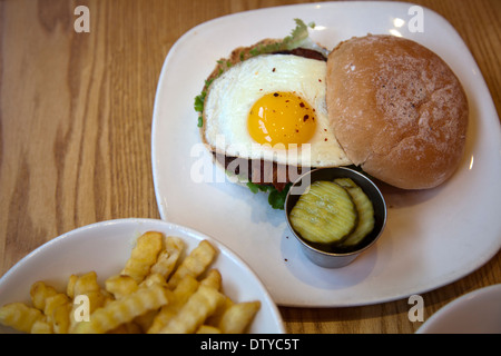 Burger mit gebratenem Ei und Pommes frites Stockfoto
