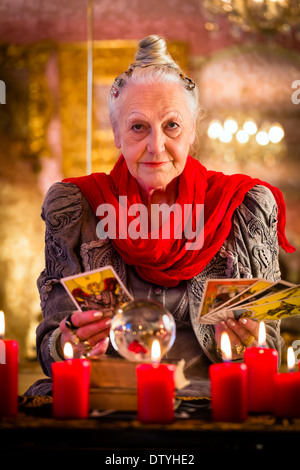 Weibliche Wahrsager oder esoterischen Oracle, sieht in der Zukunft durch das spielen ihre Tarot-Karten während einer Seance zu interpretieren Stockfoto