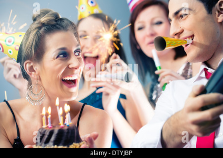 Partyvolk in bar feiert Geburtstag mit Torte Stockfoto