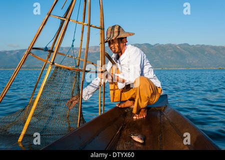 Fischer mit einem traditionellen Korb, gefangenen Fische in das Kanu, Inle-See, Shan State in Myanmar Stockfoto