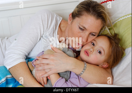 Mutter und Tochter im Bett, kuscheln umarmen Stockfoto