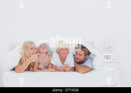 Glückliche Familie unter der Bettdecke Stockfoto