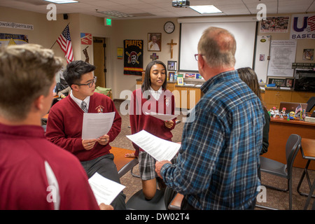 Uniformierte Afroamerikaner, kaukasischen und asiatischen Studenten interagieren Sie mit ihrem Lehrer an einer katholischen Privatschule. Stockfoto