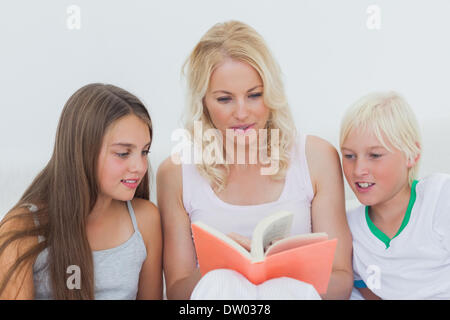 Mutter zu ihren Kindern eine Geschichte vorlesen Stockfoto