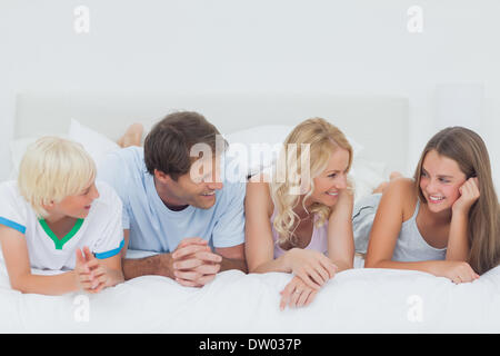 Familie auf dem Bett liegend Stockfoto