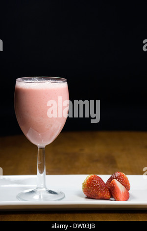 Erdbeer Smoothie und Früchte auf einem weißen Teller. Stockfoto