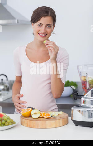 Schwangere Frau eine Traube Essen Stockfoto