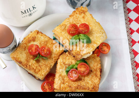 Toast mit Käse und Tomaten, serviert mit Spiegelei und eine Tasse Milch Stockfoto