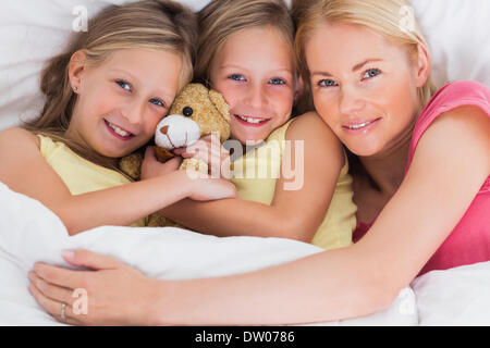 Frau Nickerchen im Bett mit ihren süßen Kindern Stockfoto