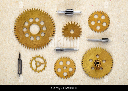 Alte Teile des Uhrwerks auf Papierhintergrund Stockfoto