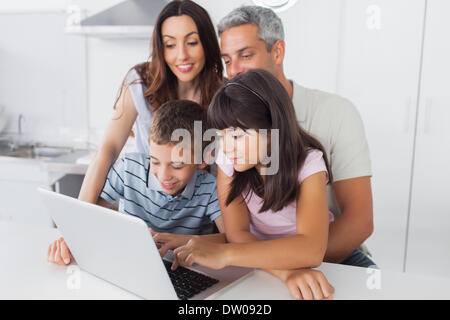 Familie in Küche, die mit ihrem Laptop sitzen Stockfoto