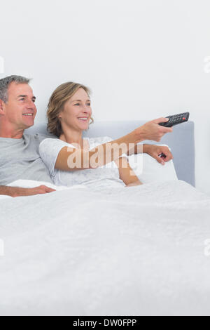 Entspannte paar Fernsehen im Bett Stockfoto