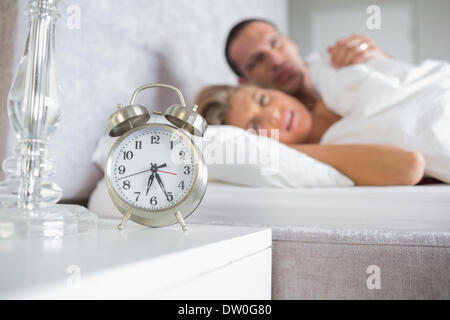 Erschöpfte paar auf der Suche auf Wecker Stockfoto