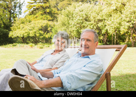 Gerne älteres paar sitzen auf Liegestühlen Stockfoto