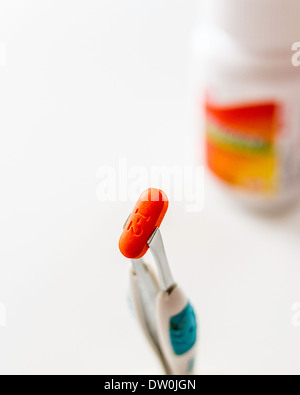 Eine generische Marke Ibuprofen Tablet mit Flasche per Pinzette daran gehalten Stockfoto