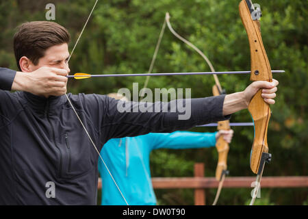 Gut aussehender Mann Bogenschießen üben Stockfoto