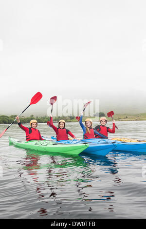 Glückliche Freunde auf einem See rudern Stockfoto