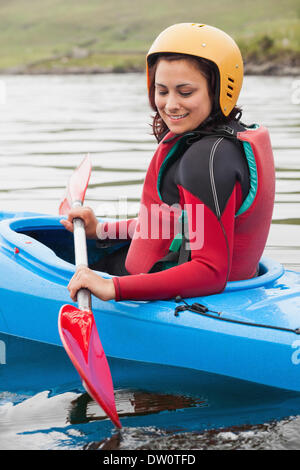 Fit Woman auf See rudern Stockfoto