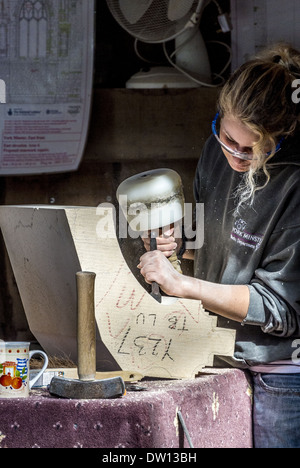 Weibliche Steinmetz Carving Steinblock im York Minster Betriebshof Stockfoto