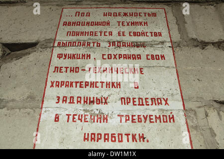 Milovice, Tschechische Republik. 25. Februar 2014. Sowjet-Ära Flugzeug Regeln in russischer Sprache an der Wand von einem verlassenen Hangar für die Flugzeuge der sowjetischen Kämpfer MiG im Bereich der sowjetischen Militärbasis in Milovice, befindet sich etwa 40 km von Prag, Tschechien. Ruinen der ehemaligen sowjetischen Militärbasis in Milovice sollen in kommenden Monaten um Platz für neue Gebäude abgerissen werden. Die Basis hat seit mehr als zwanzig Jahren aufgegeben worden, da die sowjetischen linke Tschechoslowakei im Jahr 1991 Truppen. Jetzt überlebt die verlassenen Militärbasis für die letzten Tage. Stockfoto