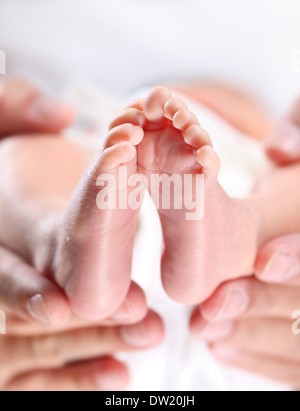 Ein Elternteil Hand zärtlich ihre Neugeborenen Füße Stockfoto