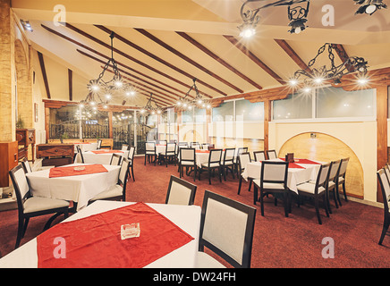 Innenraum eines modernen Restaurants. Leeren Raum mit Möbeln und alten Metall Kronleuchter, gemischt mit modernen Vintage-Design. Stockfoto