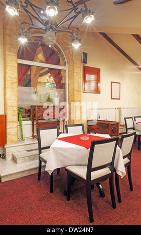 Innenraum eines modernen Restaurants. Leeren Raum mit Möbeln und alten Metall Kronleuchter, gemischt mit modernen Vintage-Design. Stockfoto