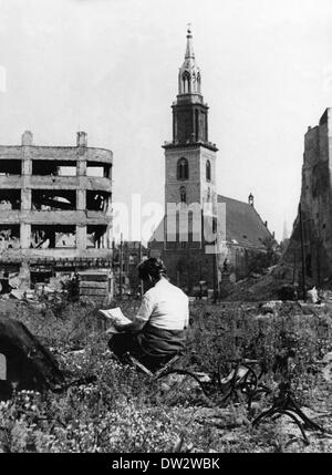 Ende des Krieges in Berlin 1945 - Zeit der Reflexion: Eine Frau steht inmitten der Trümmerstraße Marienkirche am Alexanderplatz im Berliner Stadtteil Mitte. Fotoarchiv für Zeitgeschichtee - KEIN KABELDIENST Stockfoto