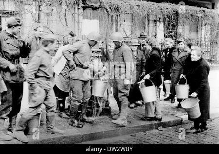 Ende des Krieges in Berlin 1945 - Besatzungstruppen versorgen das Volk mit Wasser an einer Wasserpumpe in Berlin. Fotoarchiv für Zeitgeschichte - KEIN KABELDIENST Stockfoto
