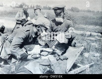 Das Bild der Berliner Illustrirten Zeitung (Berliner illustrierte Zeitung) aus dem Jahr 1915 zeigt deutsche Soldaten mit Gasmasken, die während eines Gasangriffs erste Hilfe leisteten, Standort unbekannt. Die ursprüngliche Überschrift lautet: "Verteidigung gegen englische Gasbomben: Einsatz von Sauerstoffgeräten, um die Opfer wiederzubeleben." Fotoarchiv für Zeitgeschichtee - KEIN KABELDIENST Stockfoto