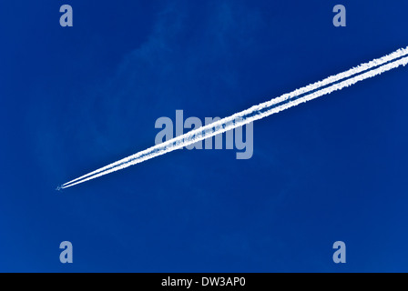 Flugzeuge fliegen in blauer Himmel mit weißen Kondensstreifen über Manchester, England, UK Stockfoto