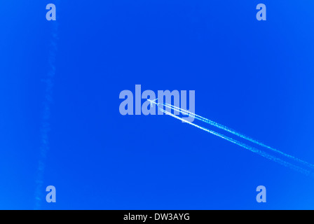 Flugzeuge fliegen in blauer Himmel mit weißen Kondensstreifen über Manchester, England, UK Stockfoto