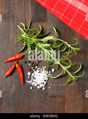 Zweige frischer Rosmarin, Pfefferkörner, rote Chilischoten und Salz aus dem Meer Stockfoto