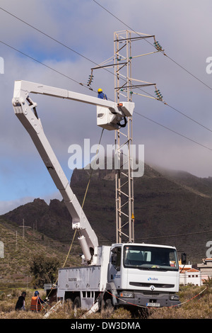 Macht Arbeitnehmer in eine Hubarbeitsbühne arbeiten am Zündkabel. Stockfoto