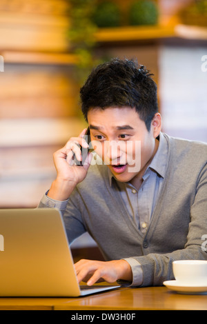 Junger Mann am Telefon im Coffee-shop Stockfoto