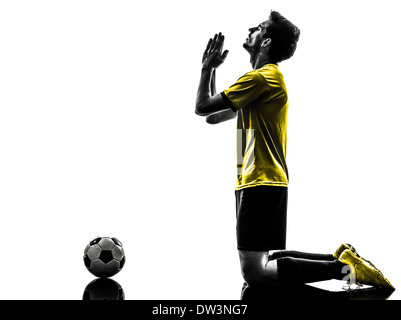 ein brasilianischer Fußball Fußball Spieler junger Mann beten in Silhouette Studio auf weißem Hintergrund Stockfoto