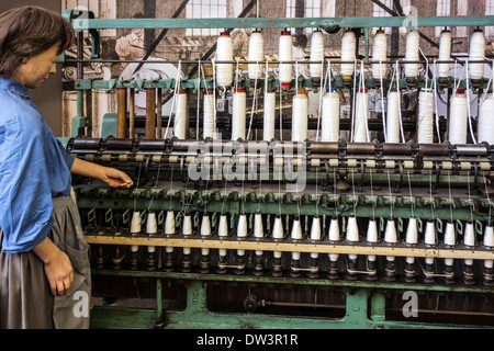 Frau am neunzehnten Jahrhundert englische Ringspinnmaschine in Spinnerei bei MIAT, industrielle Archäologiemuseum, Gent, Belgien Stockfoto