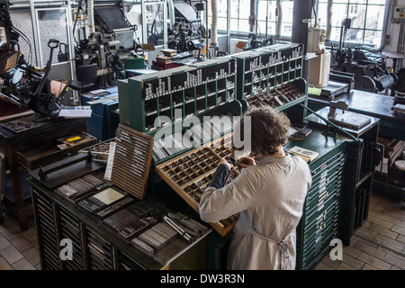 Schriftsetzer bei der Arbeit in die Setzerei im Druckgeschäft bei MIAT, industrielle Archäologiemuseum, Gent, Belgien Stockfoto