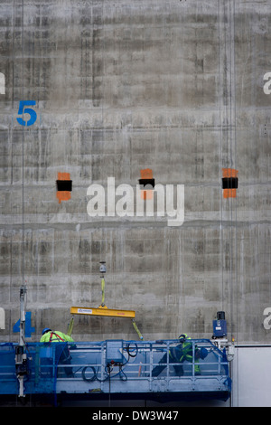 Arbeiter in Wiege auf Betonwand der Bauentwicklung in der City of London Stockfoto