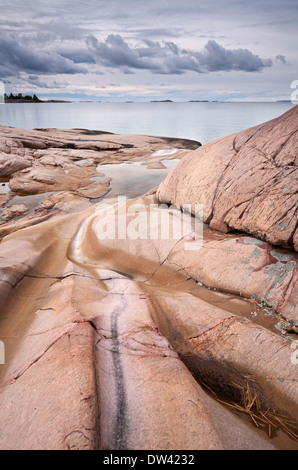 Ein Beispiel für Felsen ausgehöhlt durch Wasser und Eis mit dramatischen Sturmwolken über Georgian Bay, Ontario, Kanada. Stockfoto