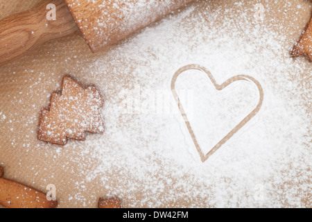 Nudelholz mit Mehl und Cookie Cutter auf das Papier zu kochen. Ansicht von oben Stockfoto