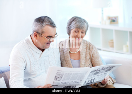Älteres Paar gemeinsam frische Zeitung lesen Stockfoto