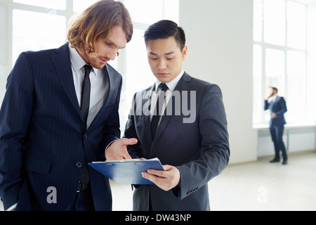 Junge Unternehmer diskutieren Plan oder Papier bei Treffen im Büro Stockfoto