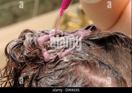 Frau, die Anwendung von Haarfärbemitteln, ihr Hinterkopf Stockfoto