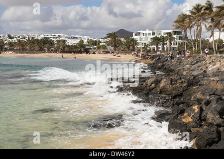 Blick entlang der felsigen Küste zu Sandstrand Playa de Las Cucharas Strand in Costa Teguise, Lanzarote, Kanarische Inseln, Spanien Stockfoto